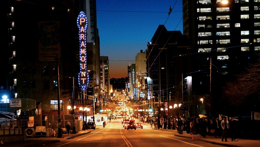 City scene at night with glowing sign