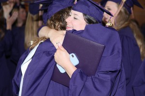 Two women in gowns hugging at lsu college of art & design graduation