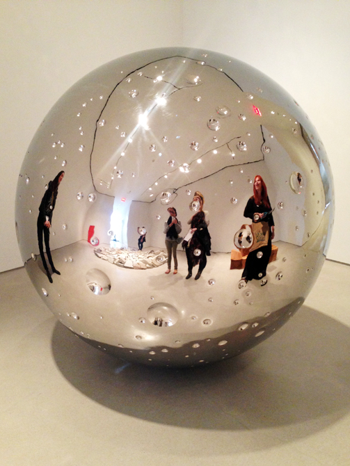 Reflection of students in a silver orb