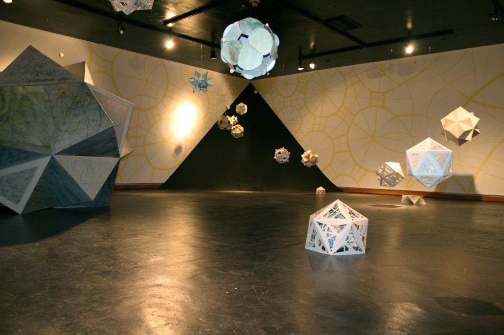 Paper geometric sculptures suspended in room, and on floor.Rebecca Kreisler LSU MFA printmaking