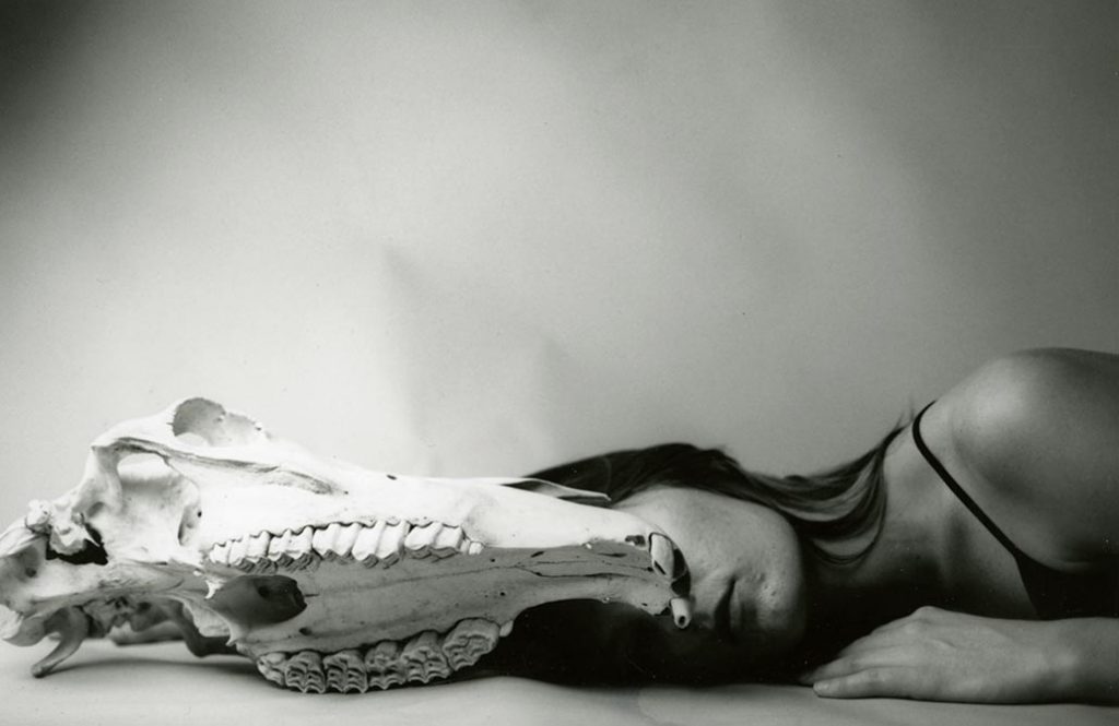 Woman lying behind animal skull, lsu intermediate photography