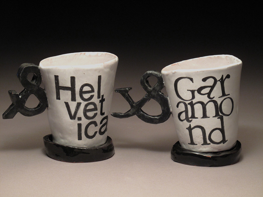 Ceramic mugs with fonts painted on sides.LSU BFA Studio Art Ceramics