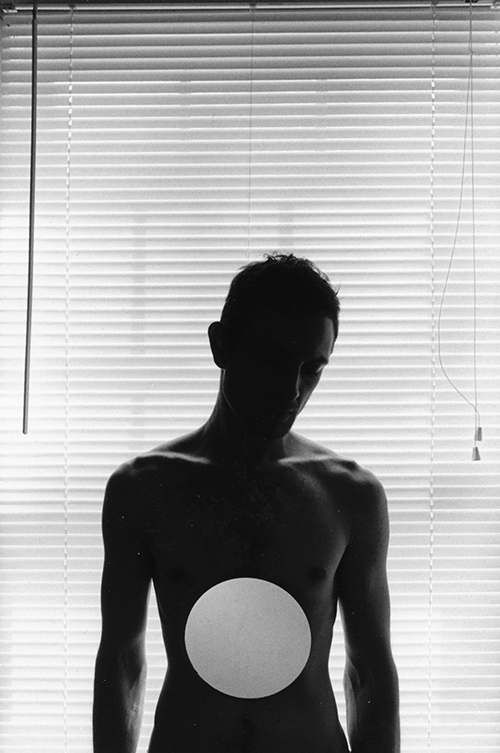 Young man with white circle on bare torso