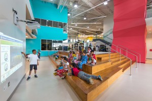 colorful elementary school space with wooden stairs, lsu interior design alumni work