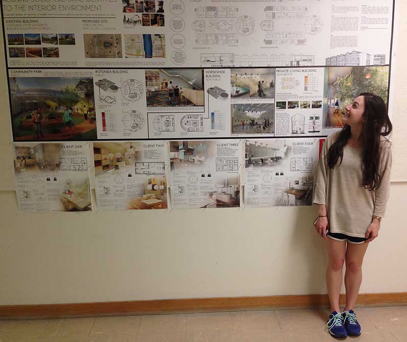 Student by wall of work.lsu interior design student work