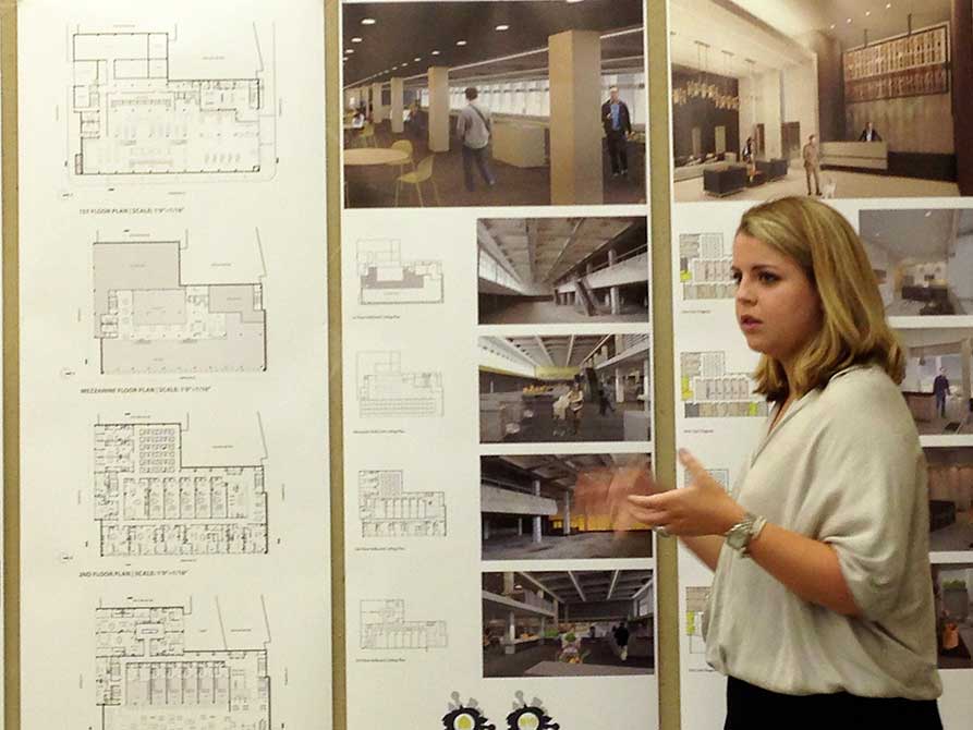 Student gesticulates as presents work.lsu interior design student work