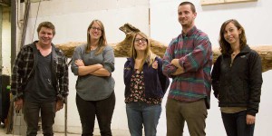 Students posing in front of a sculpture