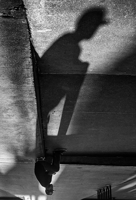 Shadow of a skateboard sitting on the curb