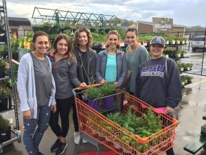 Interior design students by cart of plants