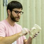 Doug Peltzman holds a ceramic cup in his hands