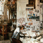 Hannah Chalew kneels while working in a crowded studio