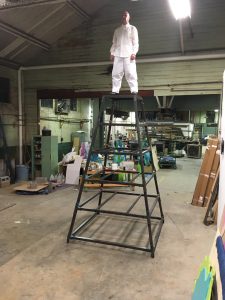 Man in white suit standing on tower