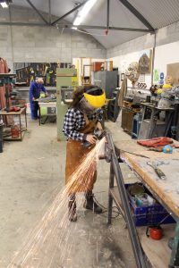 Girl welding, shooting sparks