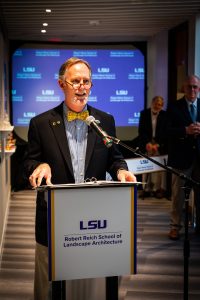 Man with yellow bow tie at podium