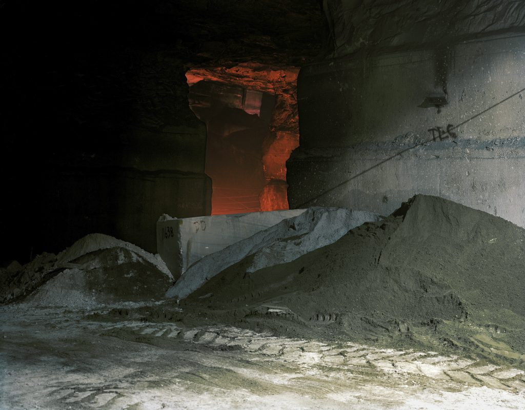 Cave with glowing red entryway in dark rock