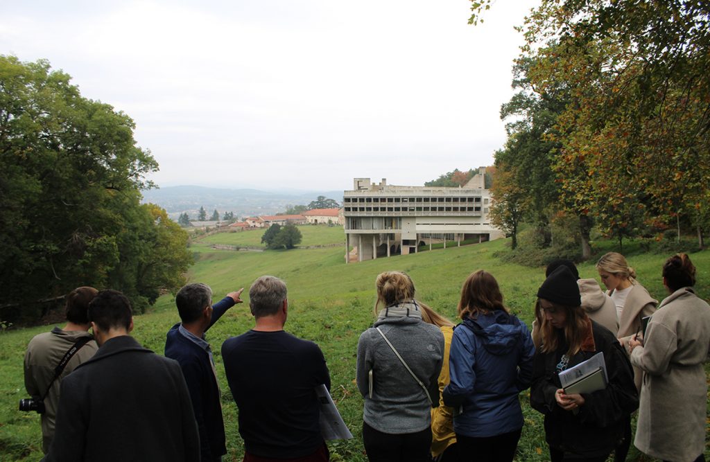 students and professors on green grass in countryside