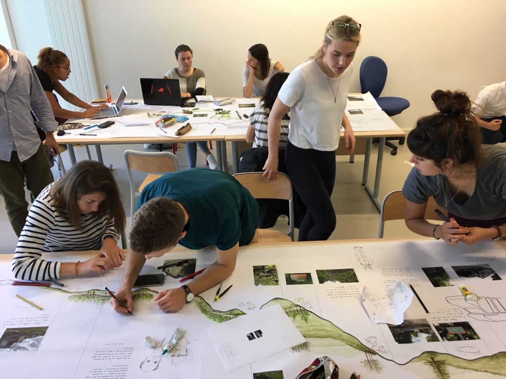 students work at table with large paper