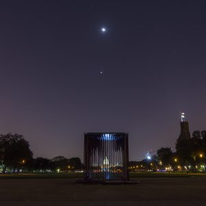 Cage with dark night sky in background.