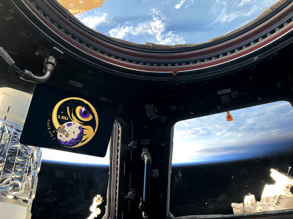 Tiger Eye 1 logo in space station, Earth in space out window