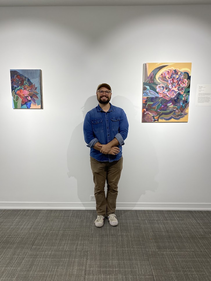 man in between two paintings on wall