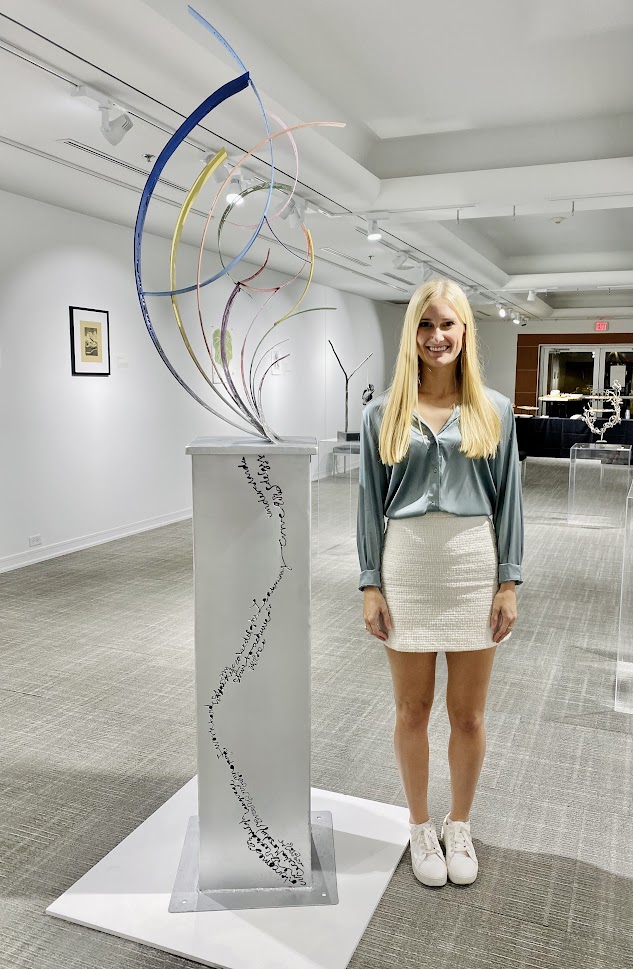 young woman by large metal sculpture