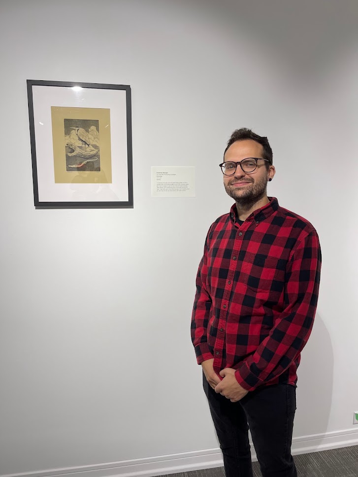 man in plaid shirt by print on wall